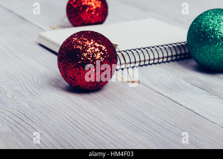 Notebook and Christmas balls on a white table closeup Stock Photo