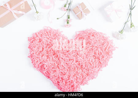 Decorative pink heart, boxes with gifts and flowers lie on a white background, top view Stock Photo
