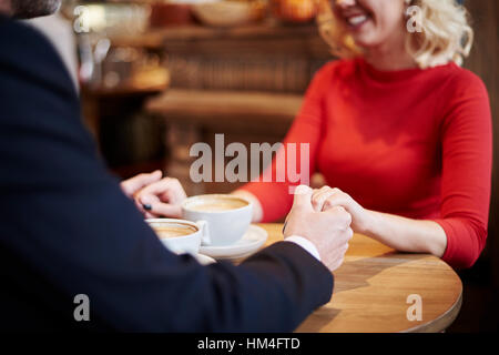 Man holding womans hands on the cafe bar Stock Photo