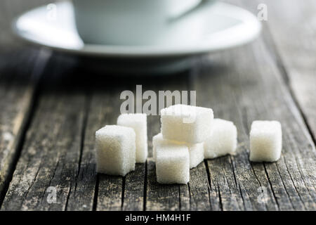 White sugar cubes on old wooden table. Stock Photo