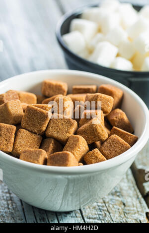 Brown and white sugar cubes in bowl. Stock Photo