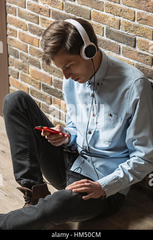 Young man wearing headphones and using phone Stock Photo