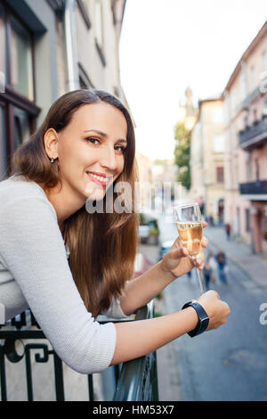 Young happy woman standing with glass of champagne Stock Photo