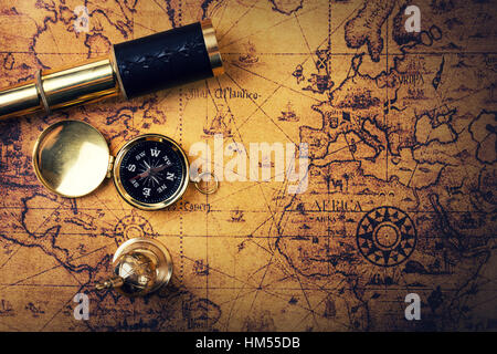 vintage compass and spyglass on old world map. copy space Stock Photo