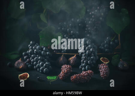 Grapes on dark rustic wooden background with figs. Stock Photo