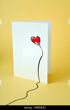 a homemade postcard, made by myself, with a red heart drawn in it, on a yellow background Stock Photo