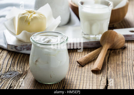 Sour cream. Organic dairy products on rustic wooden table. Stock Photo