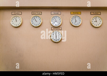 Clocks shows different time zones on old wall Stock Photo - Alamy