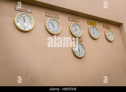 Clocks shows different time zones on old wall Stock Photo - Alamy