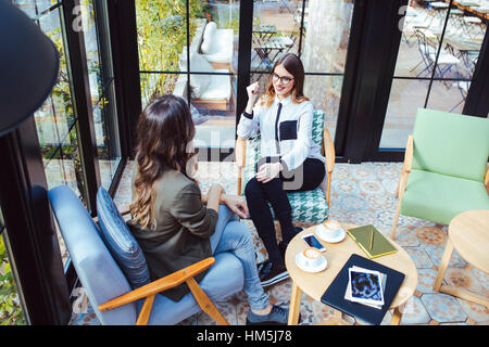High angle view of colleagues talking in cafe Stock Photo