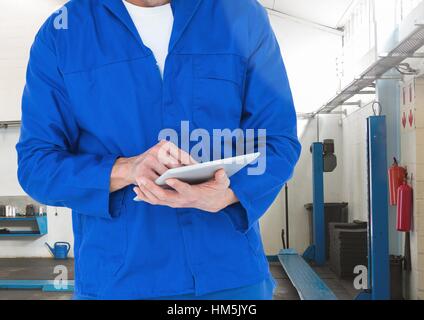 Mechanic using digital tablet in workshop Stock Photo