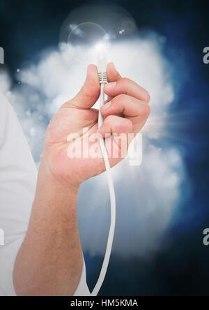 Man hand with cable and flare against digitally generated cloud Stock Photo