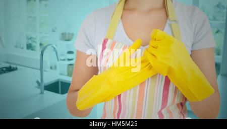 Woman removing rubber gloves in kitchen Stock Photo