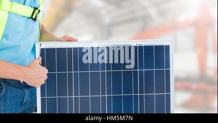 Construction worker standing with solar panel Stock Photo