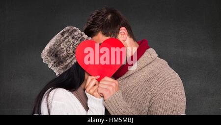 Romantic couple hiding their face behind heart Stock Photo