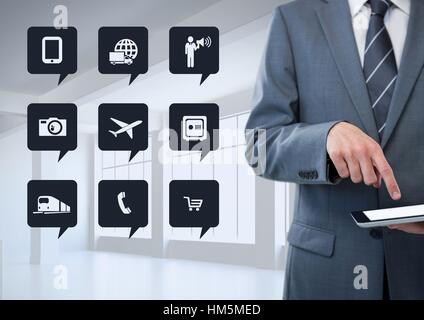 Businessman using tablet next to digitally generated app icons Stock Photo