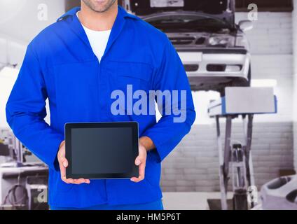 Mid section of mechanic holding a digital tablet Stock Photo