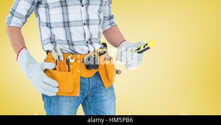 Mid section of handyman with tool belt and spirit level Stock Photo