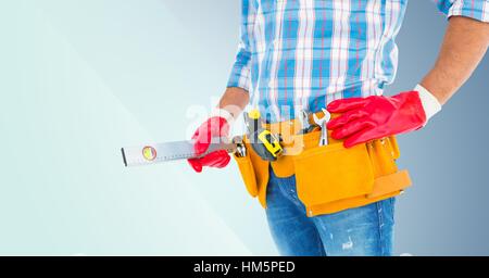 Mid section of handyman with tool belt and spirit level Stock Photo