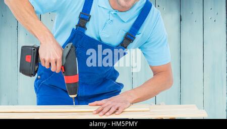 Handyman drilling wooden plank with drilling machine Stock Photo