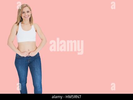 Portrait of woman in jeans standing against pink background Stock Photo