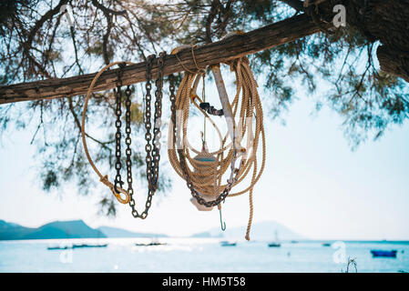 Close-up of anchor and rope on bamboo against sky Stock Photo