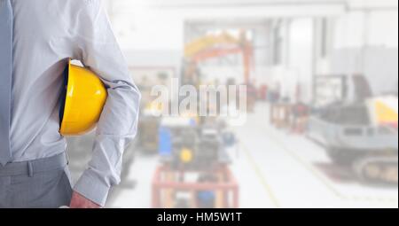 Businessman standing with hard hat at warehouse Stock Photo