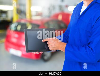 Mechanic using digital tablet in repair garage Stock Photo
