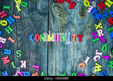 Word community from small multi-colored letters, gray wooden background Stock Photo