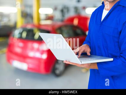 Car mechanic using laptop in repair garage Stock Photo