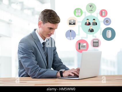 Businessman using laptop with digitally composite business icon Stock Photo