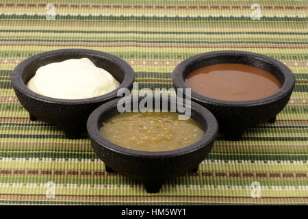 delicious sour cream, salsa verde and roja or tomatillo sauce made with hot peppers and fresh tomatillos Stock Photo