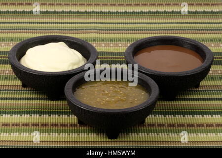 delicious sour cream, salsa verde and roja or tomatillo sauce made with hot peppers and fresh tomatillos Stock Photo