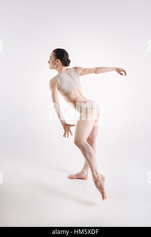 Strong young gymnast dancing against white background Stock Photo