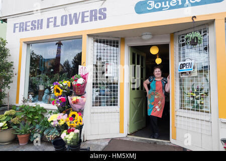 Portrait of female florist standing in doorway of flower shop Stock Photo