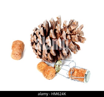 Big pine cone and champagne wine corks with muselet. Isolated on white background. Stock Photo