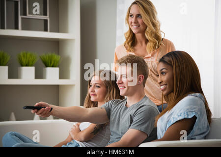 Young people watching television together Stock Photo