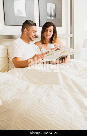 Young couple reading newspaper in morning Stock Photo