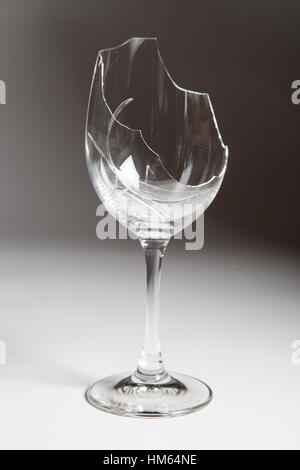 Broken red wine glass without wine in it. - Graded background Stock Photo