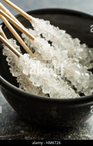Crystallized sugar on wooden stick in bowl. Stock Photo