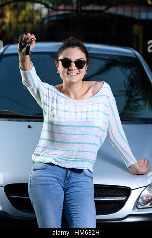 happy smile woman hold key of new car outside Stock Photo