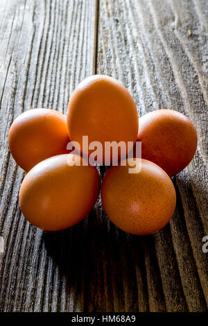 A half dozen eggs on a rustic wooden table Stock Photo