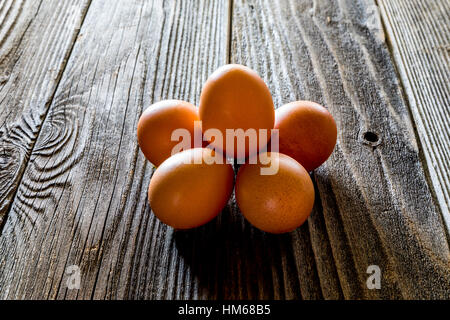 A half dozen eggs on a rustic wooden table Stock Photo