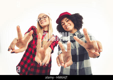 Studio lifestyle portrait of two best friends hipster girls going crazy and having great time together. Isolated on white background. Stock Photo