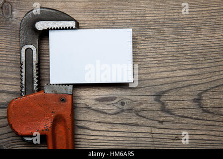 Set of pipes plumbing tools fittings and business card on the wooden background Stock Photo