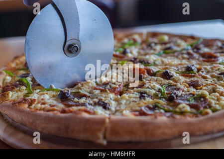 Wheel slicer slices a pizza Stock Photo