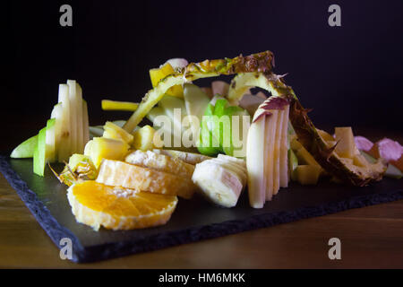 Fruit salad dish on wooden table with black background Stock Photo