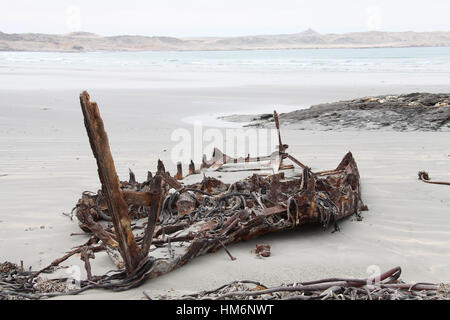 Remains of a boat on the beach at Grosse Bucht on the Luderitz Peninsula in Namibia Stock Photo