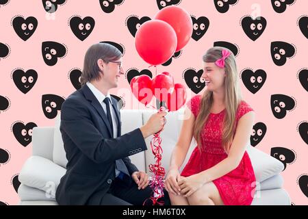 Happy man giving red balloons to woman Stock Photo