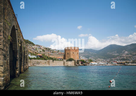 Castle walls Red Tower and Shipyard in Alanya in Turkey near harbor on Mediterranean sea coast. Medieval fortress built by Seljuk Sultan Keykubat Stock Photo